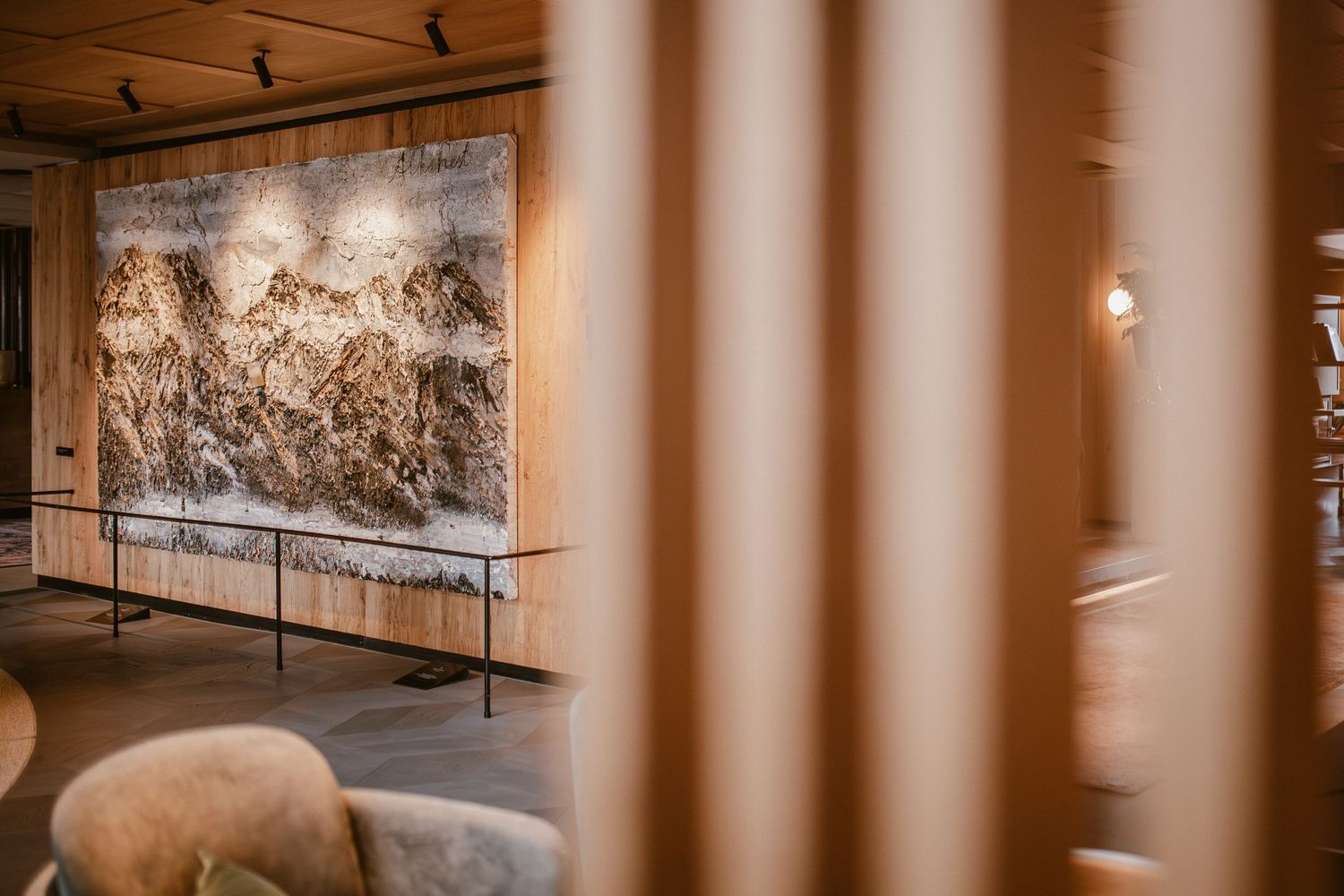 A museum gallery showing a large landscape painting with viewing barriers.