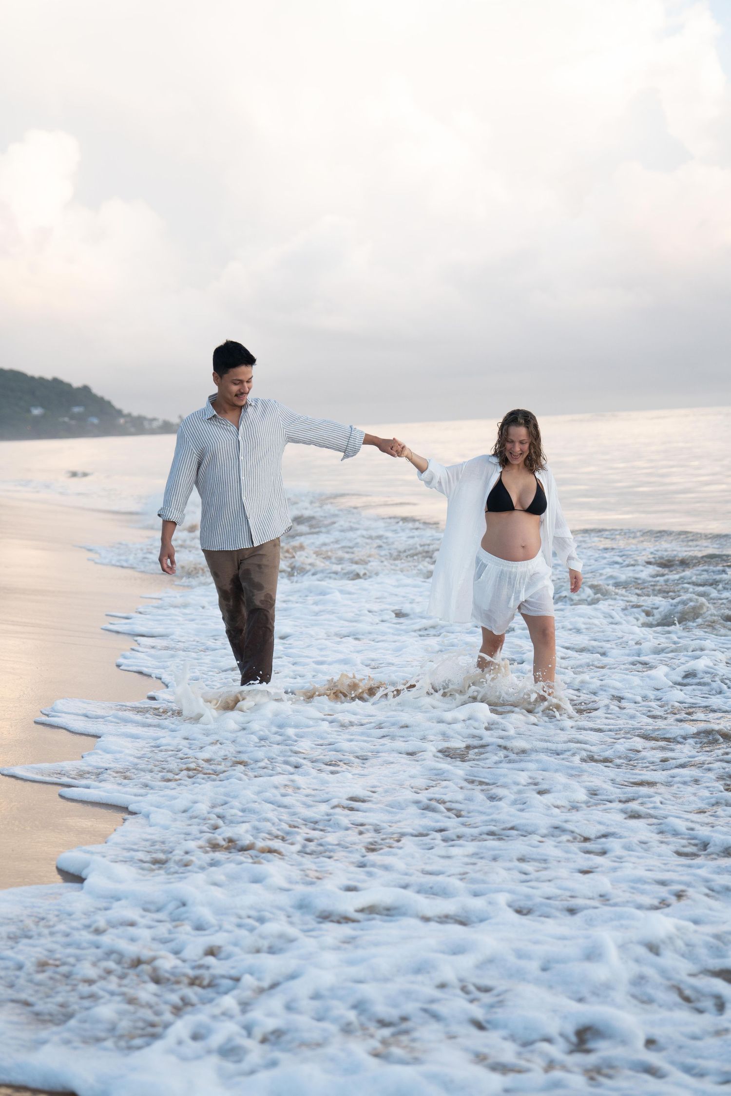 Couple marchant au bord des vagues sur une plage de Guyane