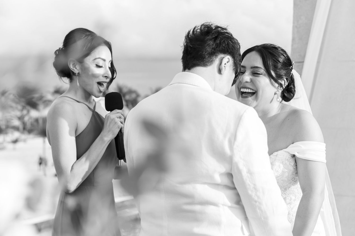 A candid black and white moment captured during a wedding celebration.