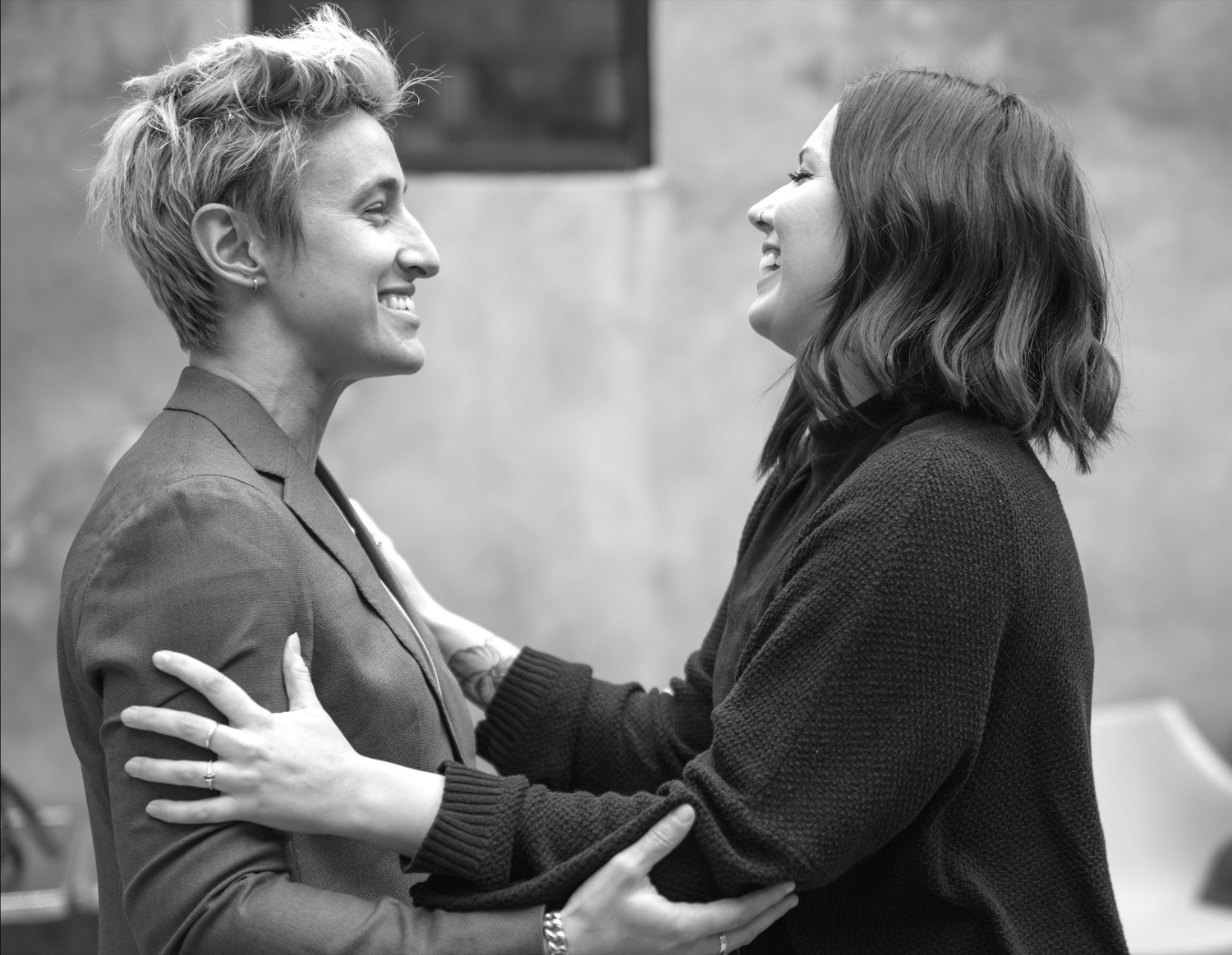 Two people embrace warmly in a black and white photograph.