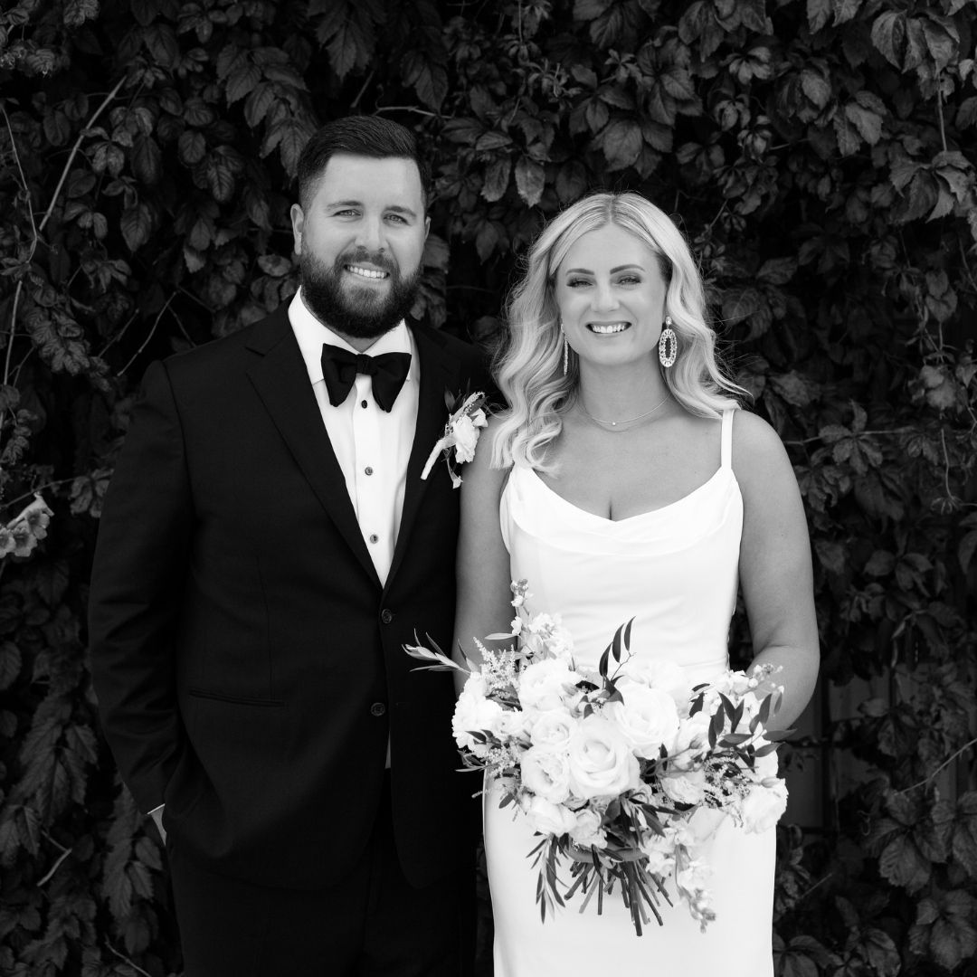 Classic black and white portrait of wedding couple with floral bouquet.