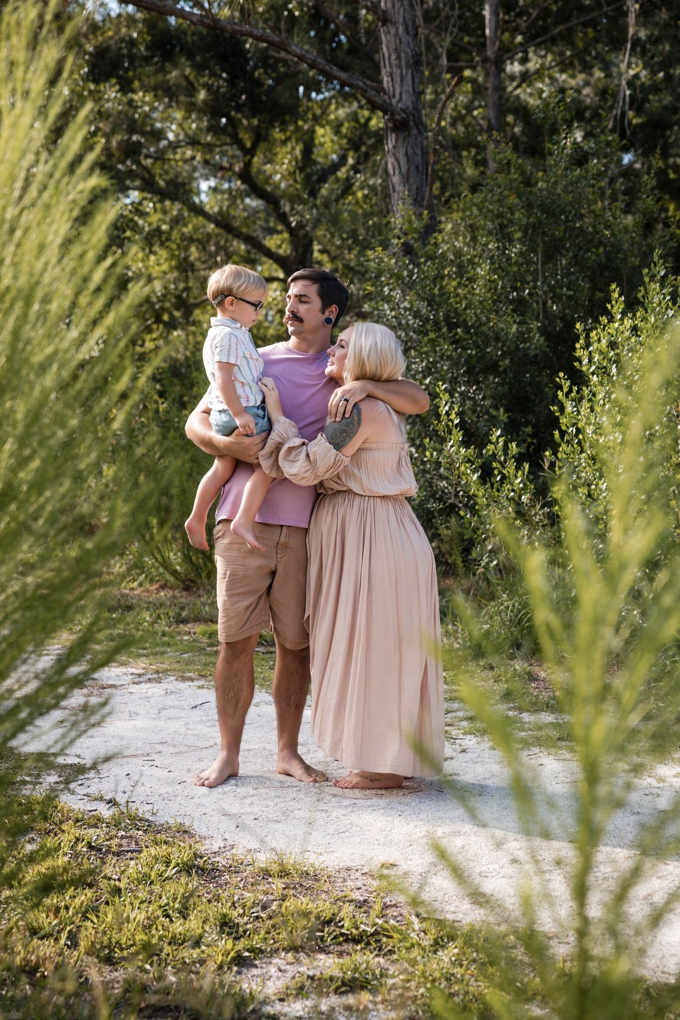 Family maternity portrait with pregnant woman, partner, and their young son.
