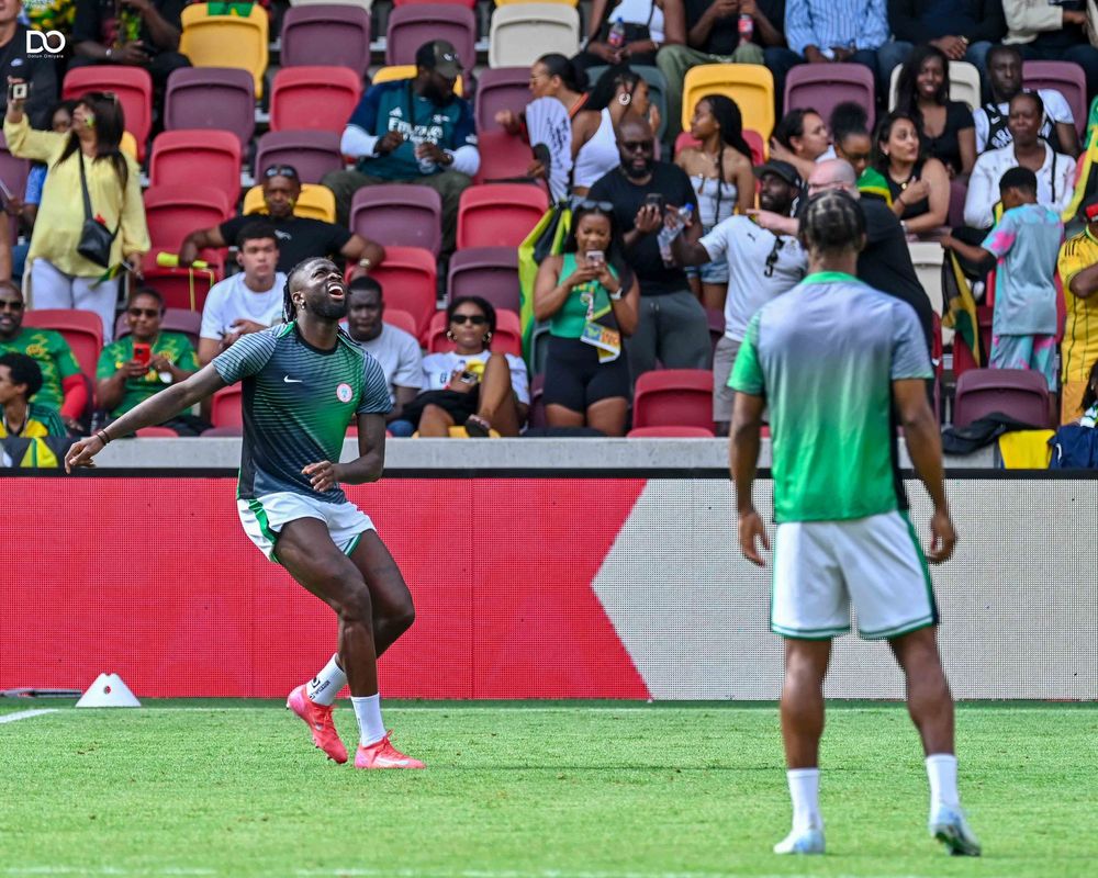 Athletes training on a soccer field with stadium crowd visible in the background.