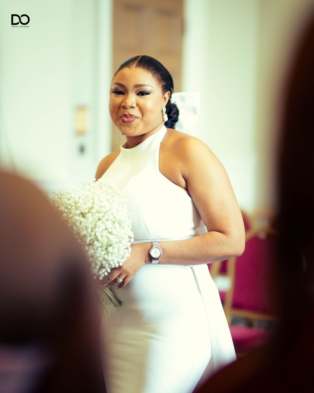 Wedding preparation scene with white floral decorations in soft lighting.