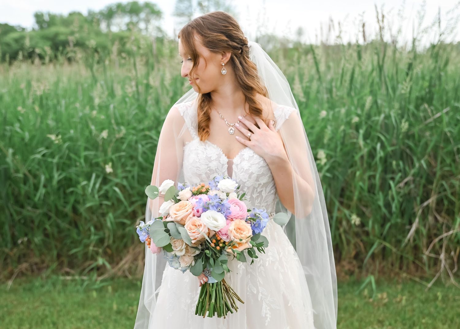 Close-up of bride and groom holding hands showing wedding dress lace detail.