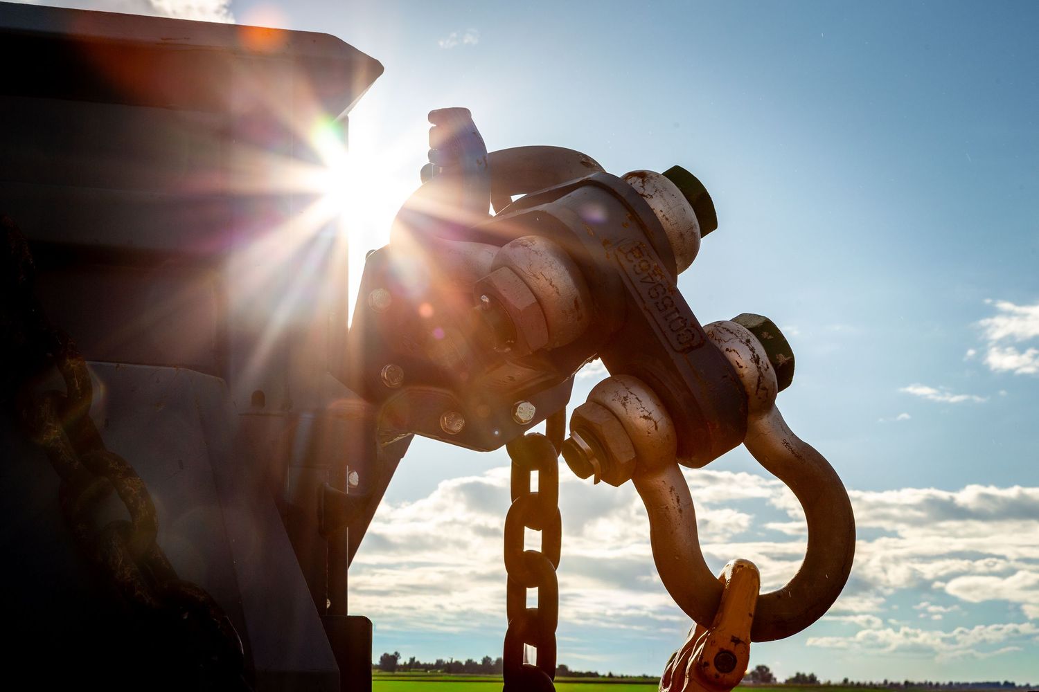 Silhouetted figure performing a bicycle trick against a bright sunlit sky with lens flare effects.