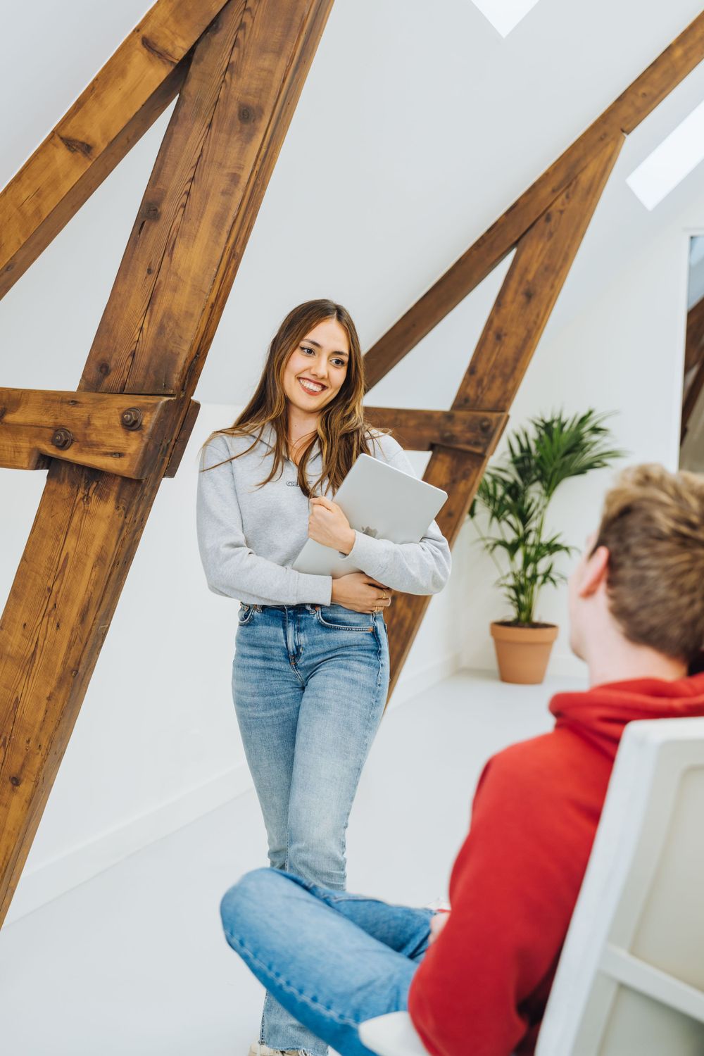 Professional interaction in a modern office space with exposed wooden beams.