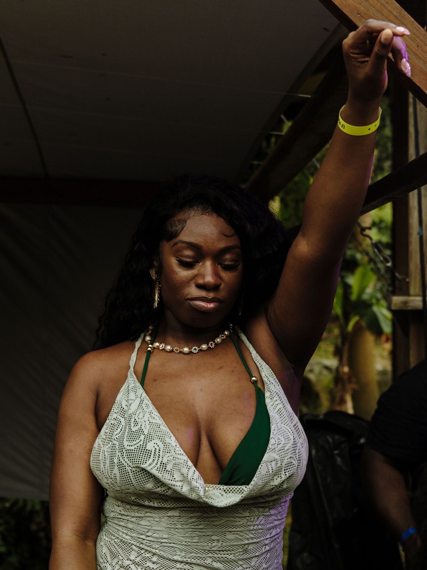Dancing figure in white lace tank top performing dynamic movements in dark atmospheric setting.