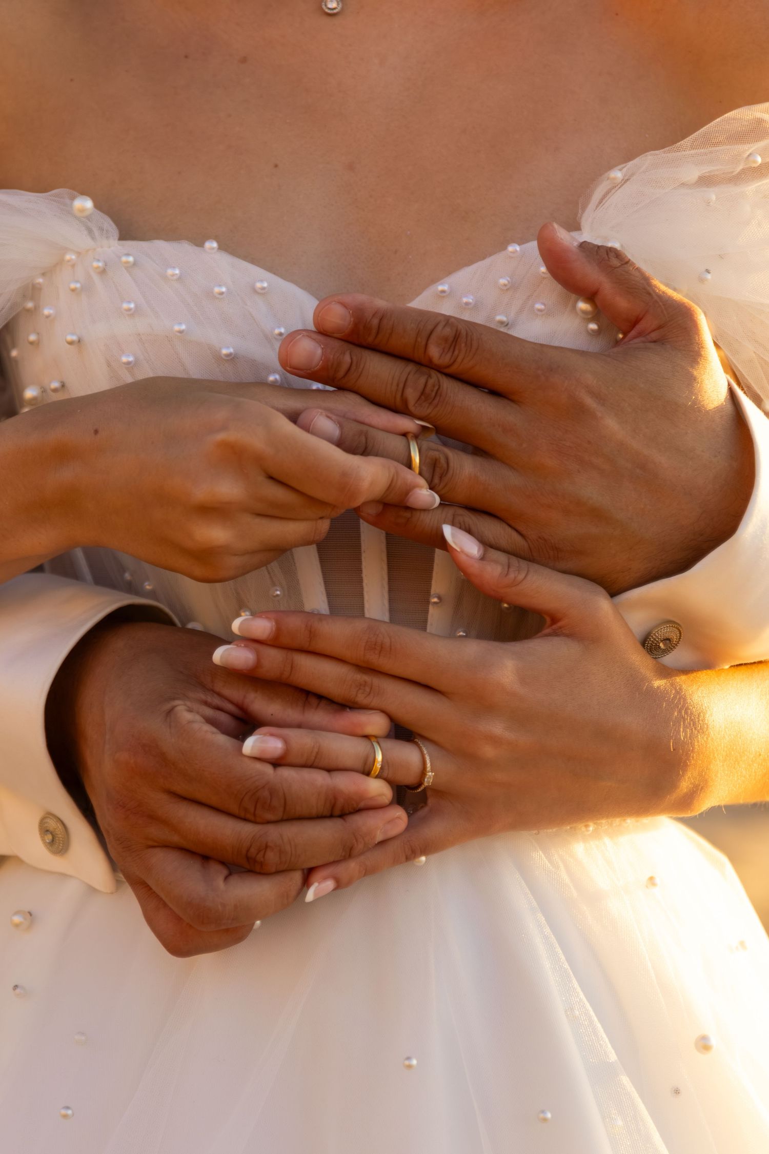 Close-up shots of hands with wedding rings being exchanged against a white background.