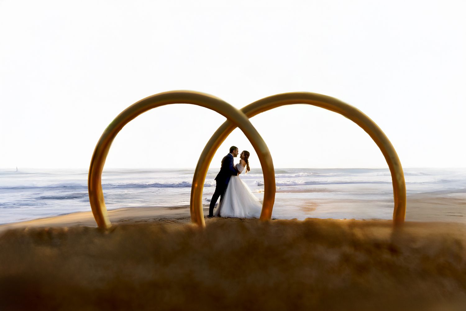 Artistic silhouette of wooden arches on beach at sunset creating symmetrical frames.