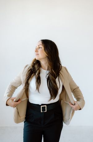 Stylish business casual outfit featuring beige blazer and black trousers with statement belt.