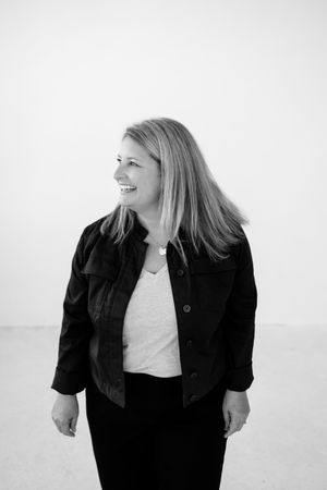 Black and white portrait showing casual confidence in dark denim jacket.