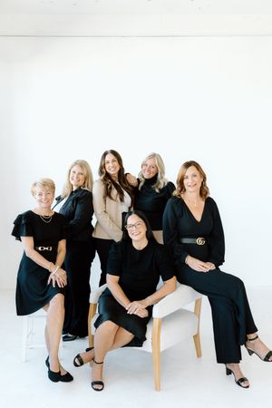 Casual group portrait with team members styled in complementary black and neutral tones.