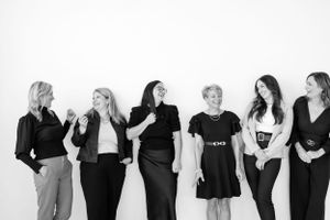 Candid black and white group shot showing natural interaction between team members.