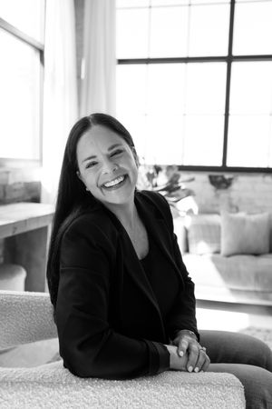A relaxed black and white portrait of someone sitting comfortably on a couch in an office setting.