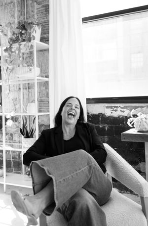 A spontaneous black and white photo capturing pure joy and laughter in a modern living space.