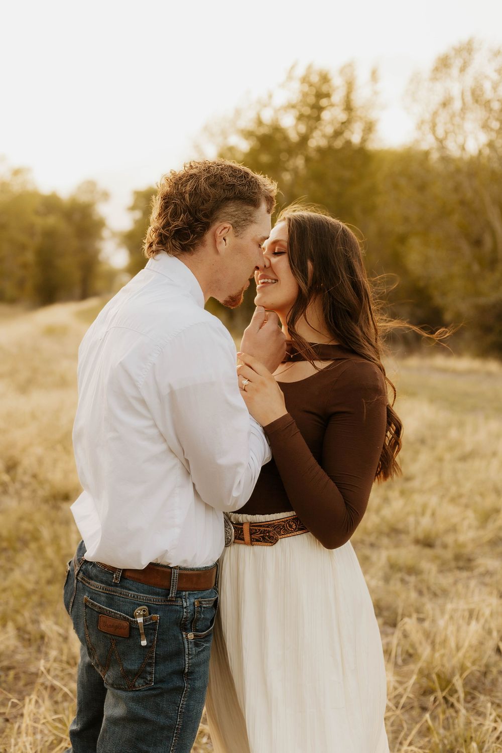 Western Romantic couple shares intimate moment in golden evening light.