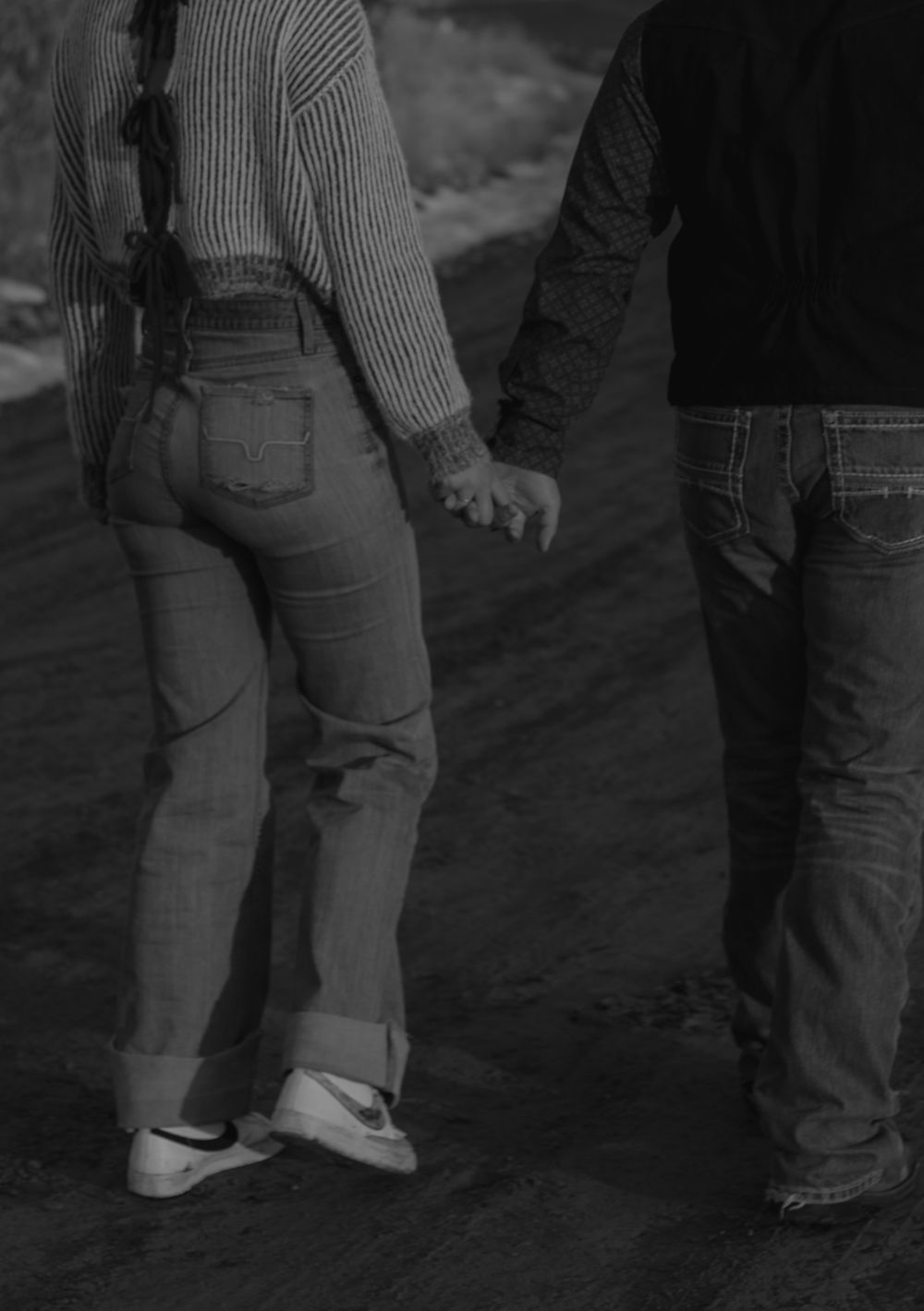 Close up of western couple holding hands and walking away.