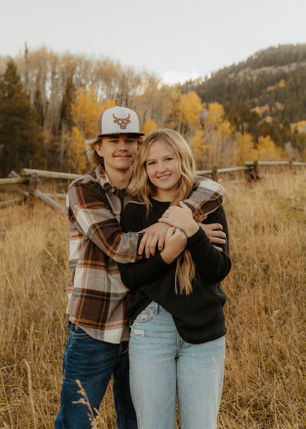 Autumn engagement photoshoot in a mountain meadow with golden aspen trees.