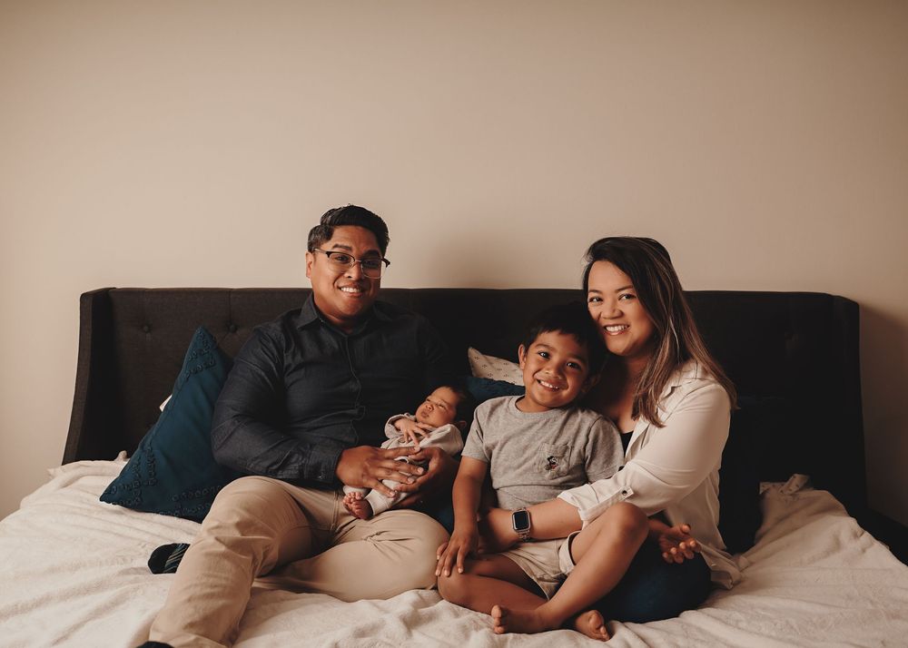 Sequence of photos showing two adults and an infant cuddling together on a dark sofa bed.