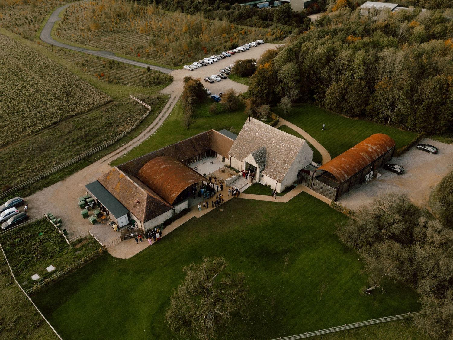 Aerial view of a rustic wedding venue with barns and surrounding countryside.