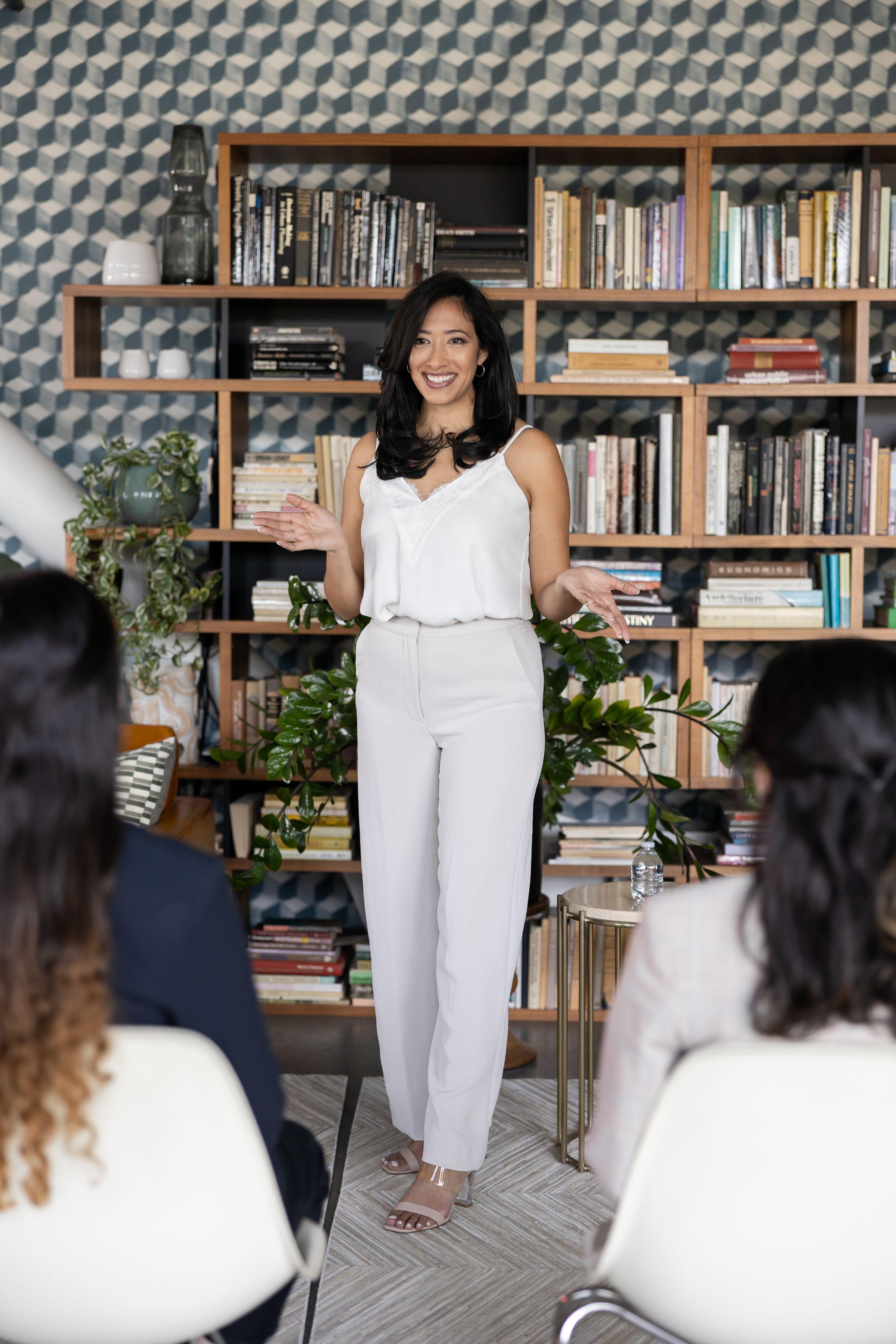 Latina salary negotiator coach for woman money mindset business owner in Seattle, WA standing in front of women presenting speaking