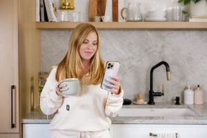 Fuller nutrition meal prep service women owned Seattle, WA lifestyle product busy woman on phone with mug in hand