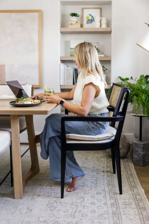 Fuller nutrition meal prep service women owned Seattle, WA lifestyle product woman sitting at table eating and working