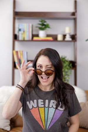 Jamie McGillen author and editor in Enumclaw, WA personal branding photoshoot headshot winking at camera fun weird livingroom set