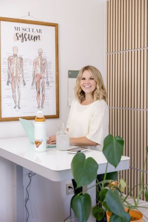 woman buoyant chiropractic in Tacoma, WA standing at standing desk for lifestyle headshot working on computer