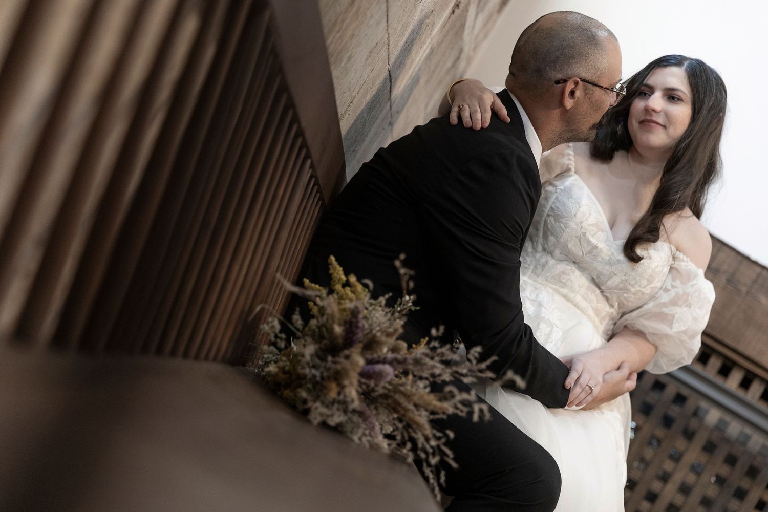 Wedding photography session in rustic indoor venue with dramatic lighting.