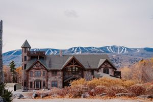 Rustic stone lodge wedding venue with ski mountain backdrop in autumn.