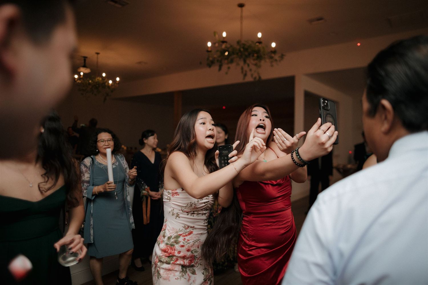 Excited wedding guests dancing and celebrating at an indoor reception.