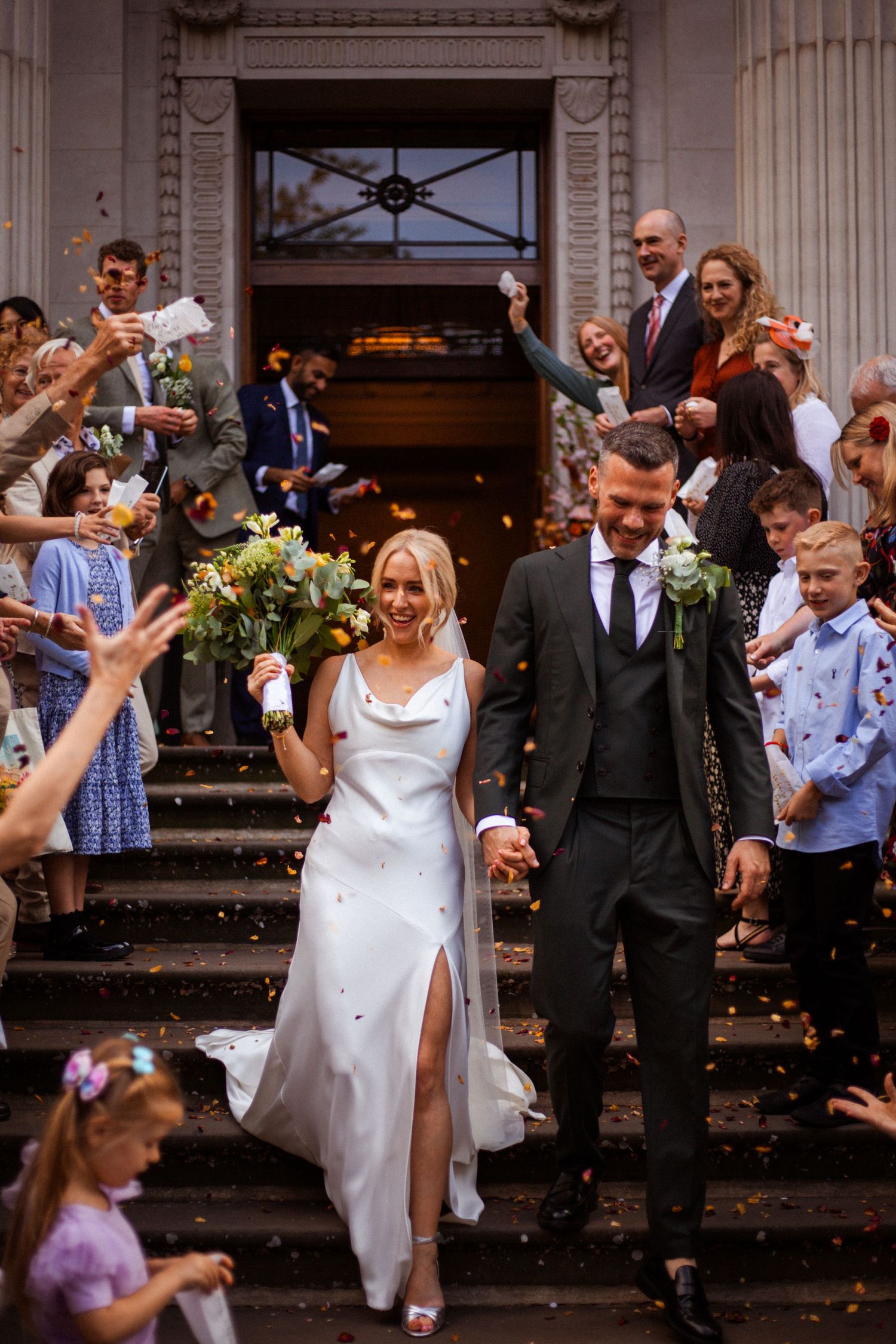 bride and groom being showered in confetti on the steps of Old Marylebone Town Hall in London by Dominique Lauren Photography