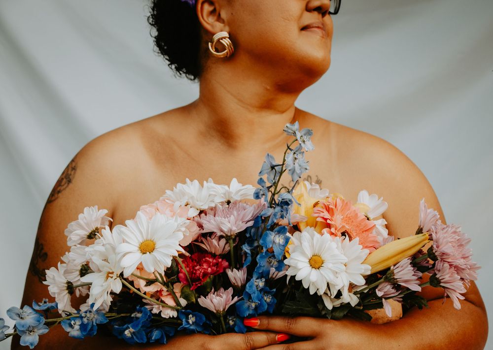 Showing support for breast cancer awareness through pink-themed clothing, ribbons, flowers, and group unity during a photo session
