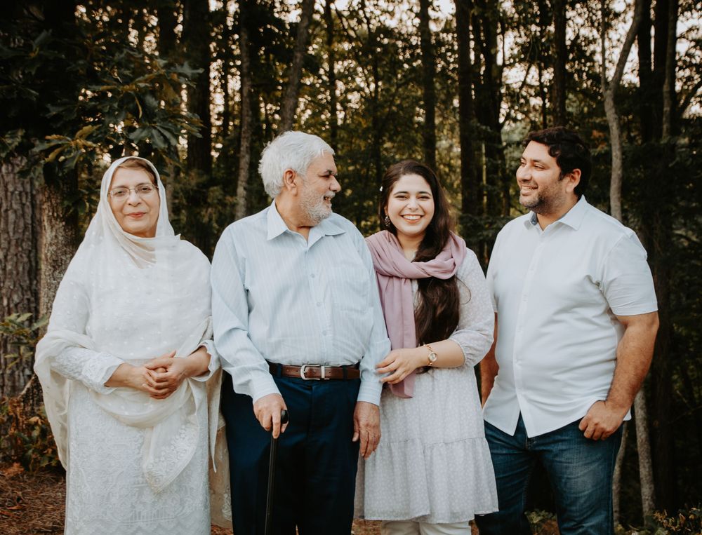 Smiling family posed together outdoors, capturing a warm and candid moment during a portrait session