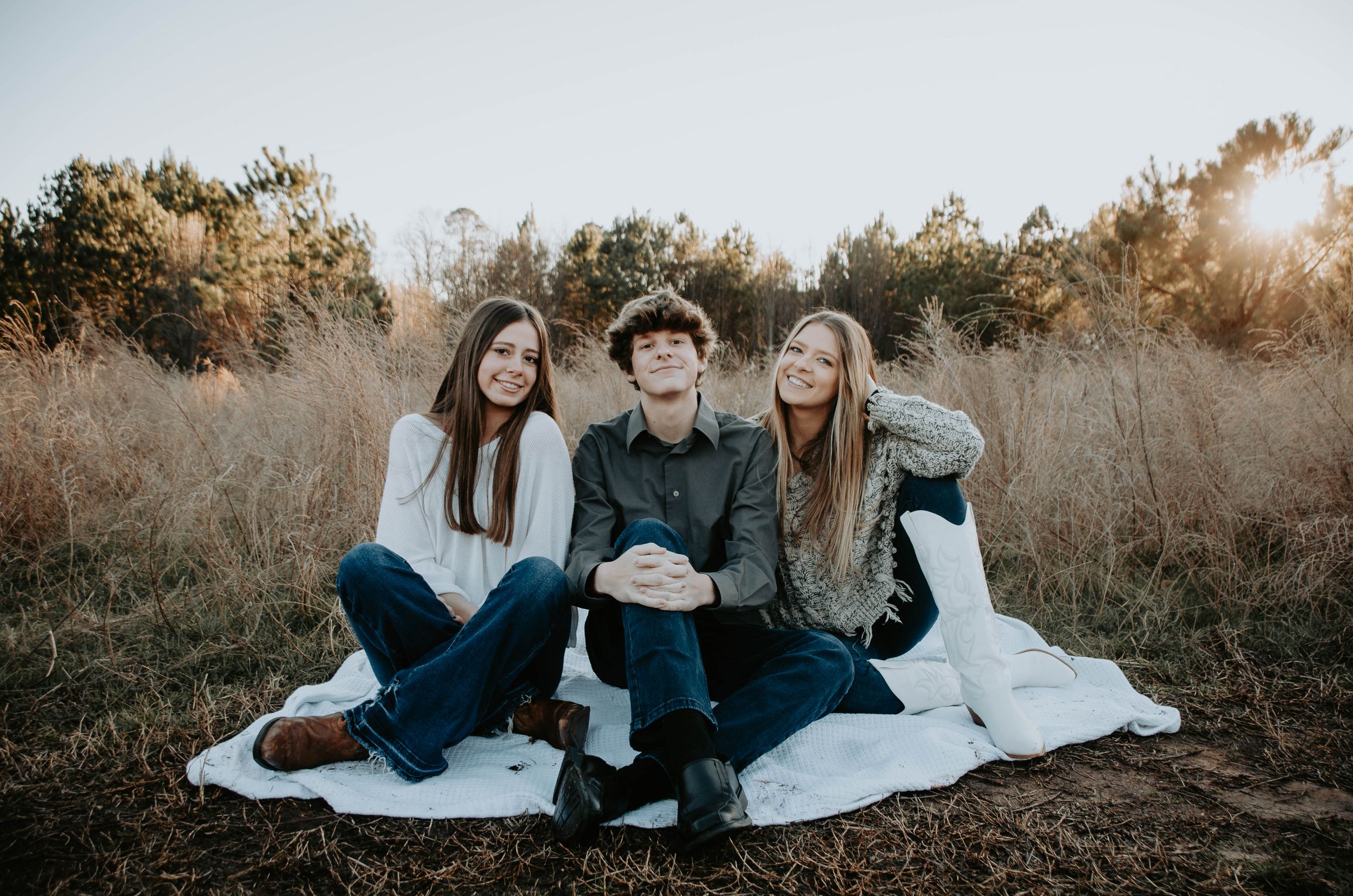 Smiling family posed together outdoors, capturing a warm and candid moment during a portrait session