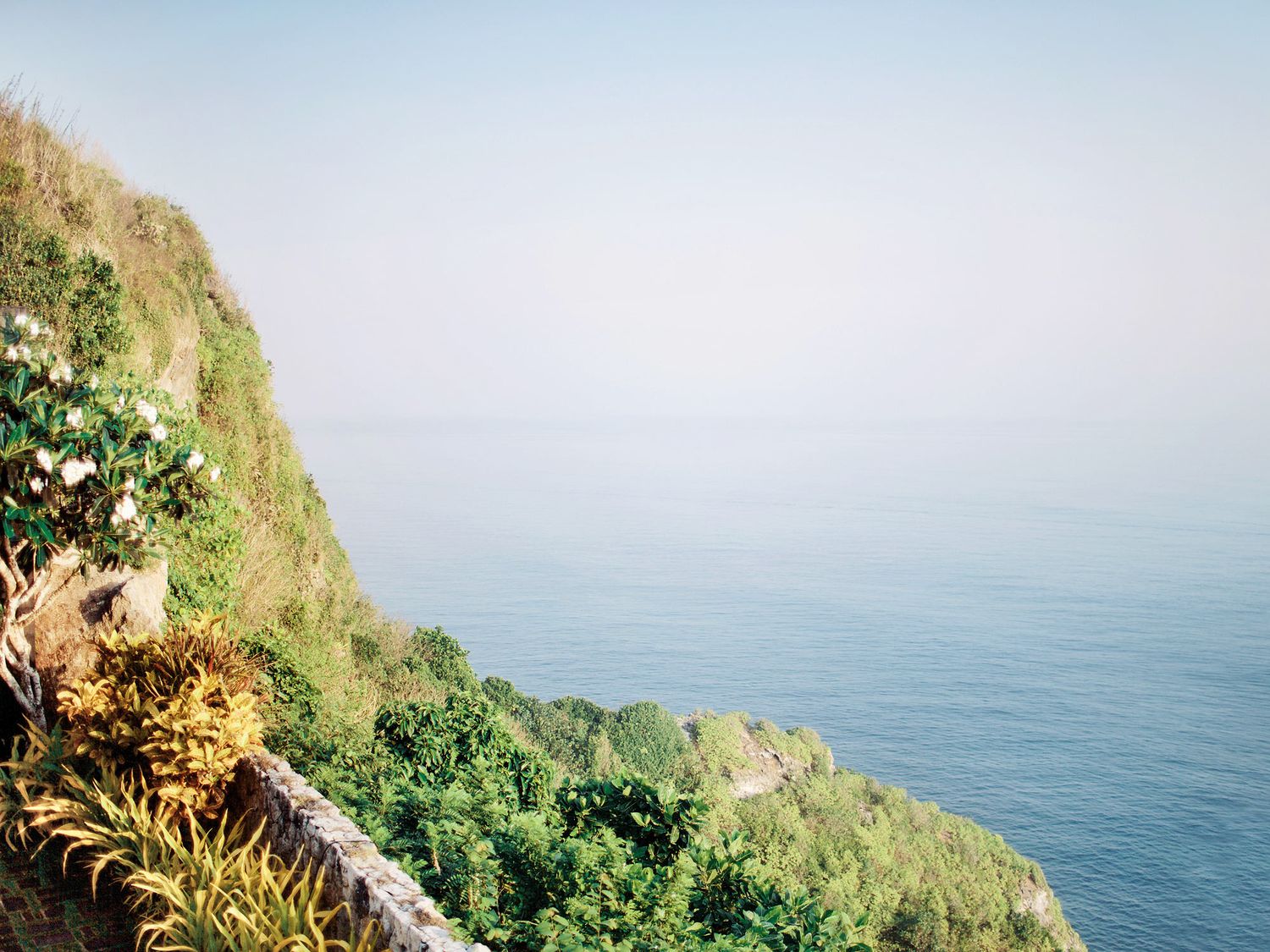A picturesque view overlooking the ocean and surrounded by lush greenery, ideal for a wedding at Bulgari Resort Bali.