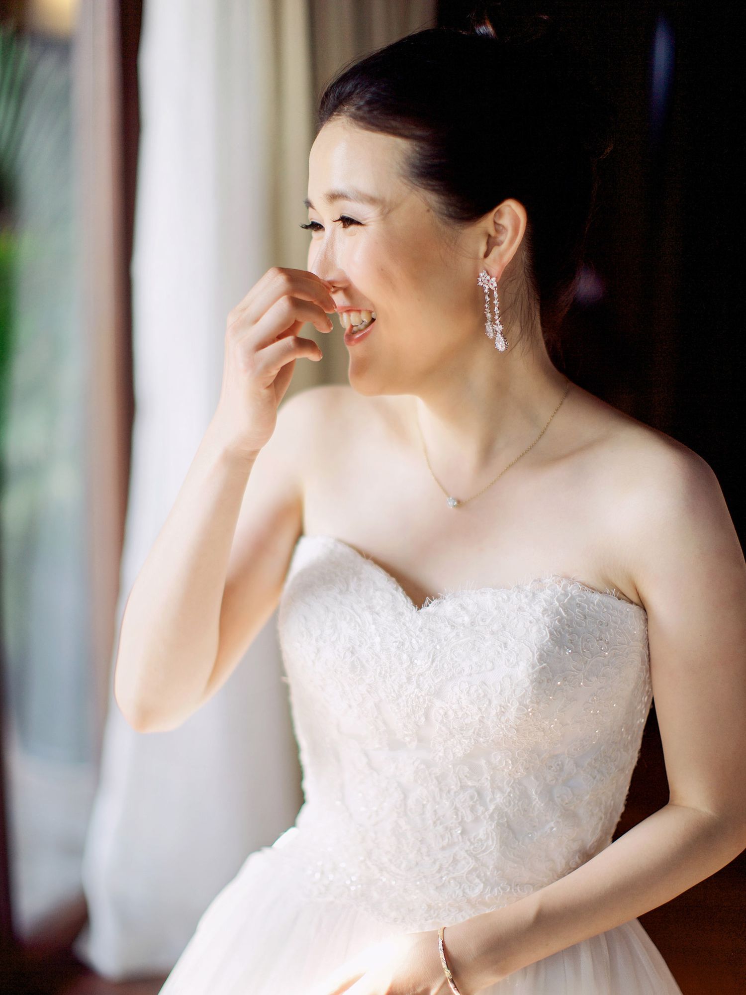 A smiling bride in a wedding dress at Bulgari Resort Bali, getting ready for her special day.
