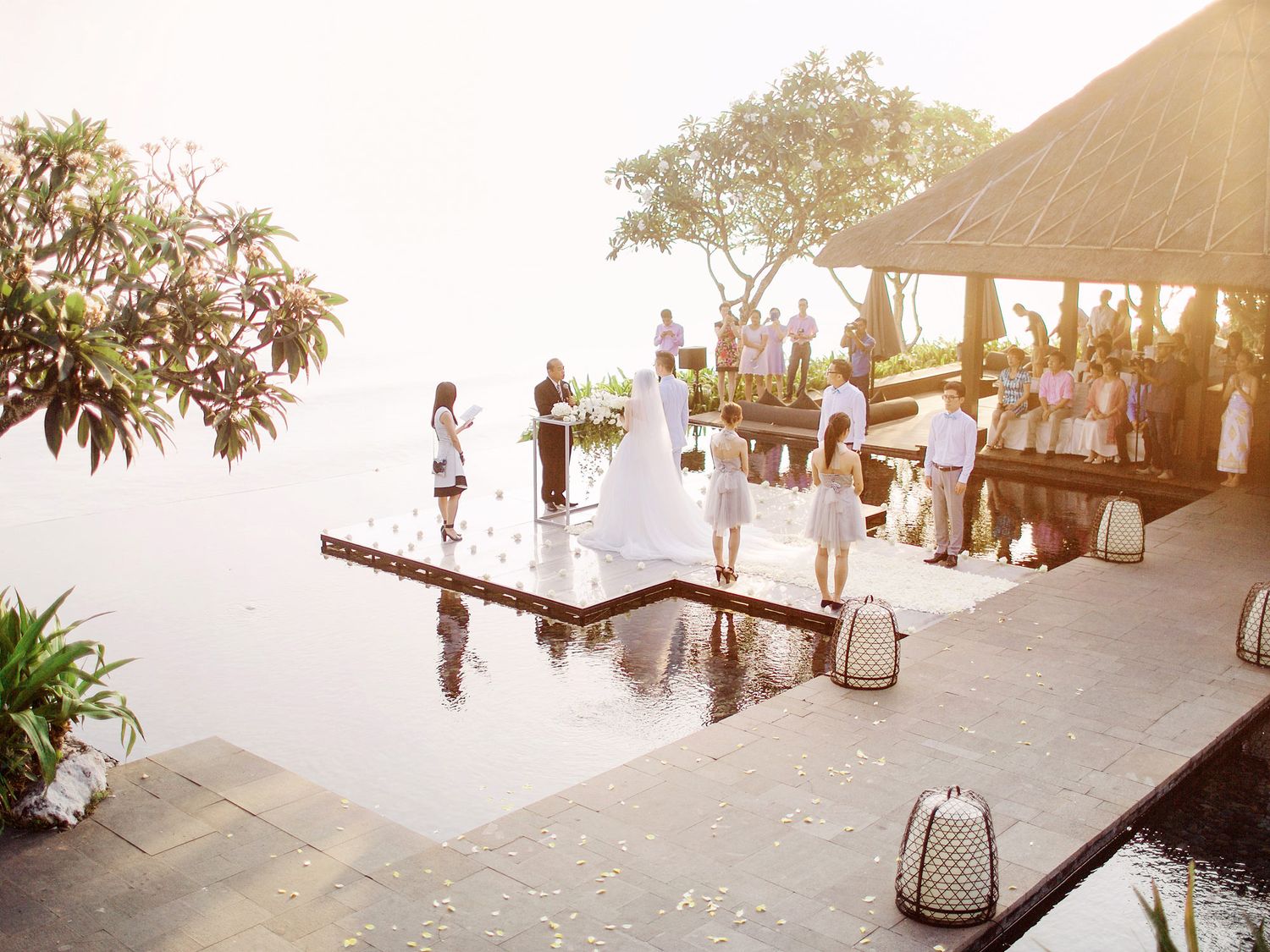 A beautiful wedding ceremony taking place on a dock by the water at Bulgari Resort Bali.
