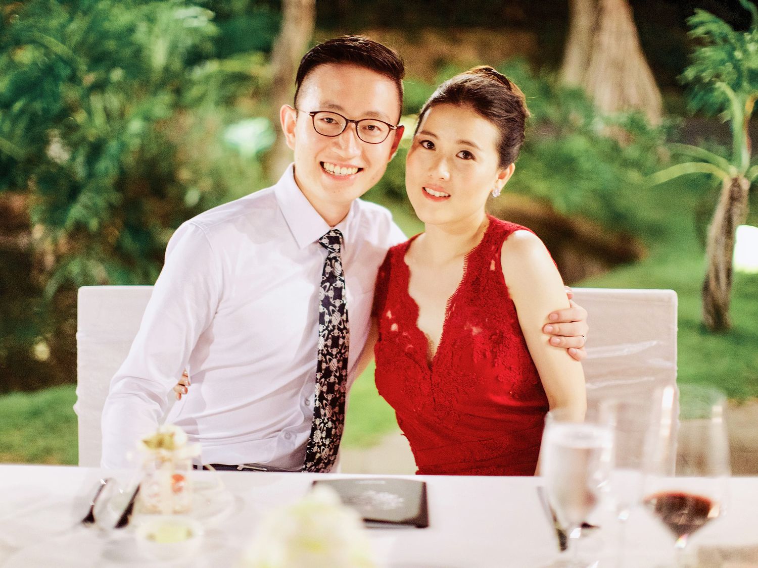 Elegant bride and groom in formal attire seated at a table during a luxurious wedding reception at Bulgari Resort Bali.