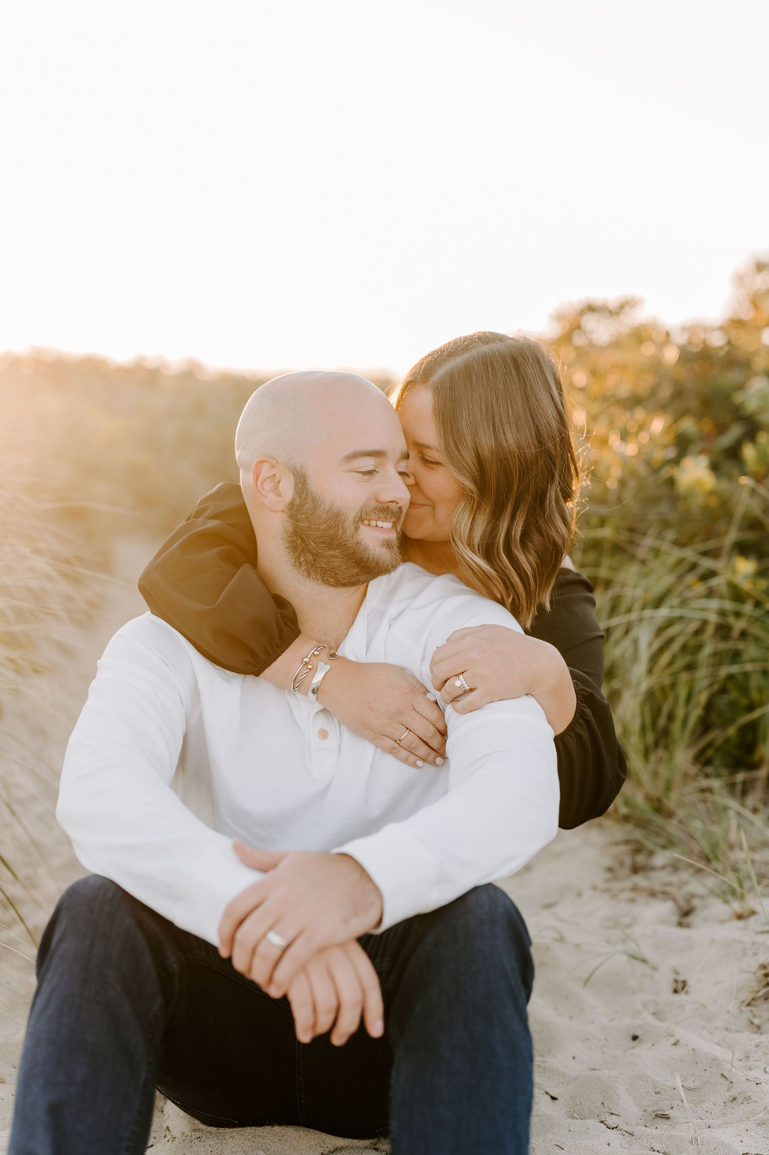 A couple shares tender moments during a sunset beach photoshoot.