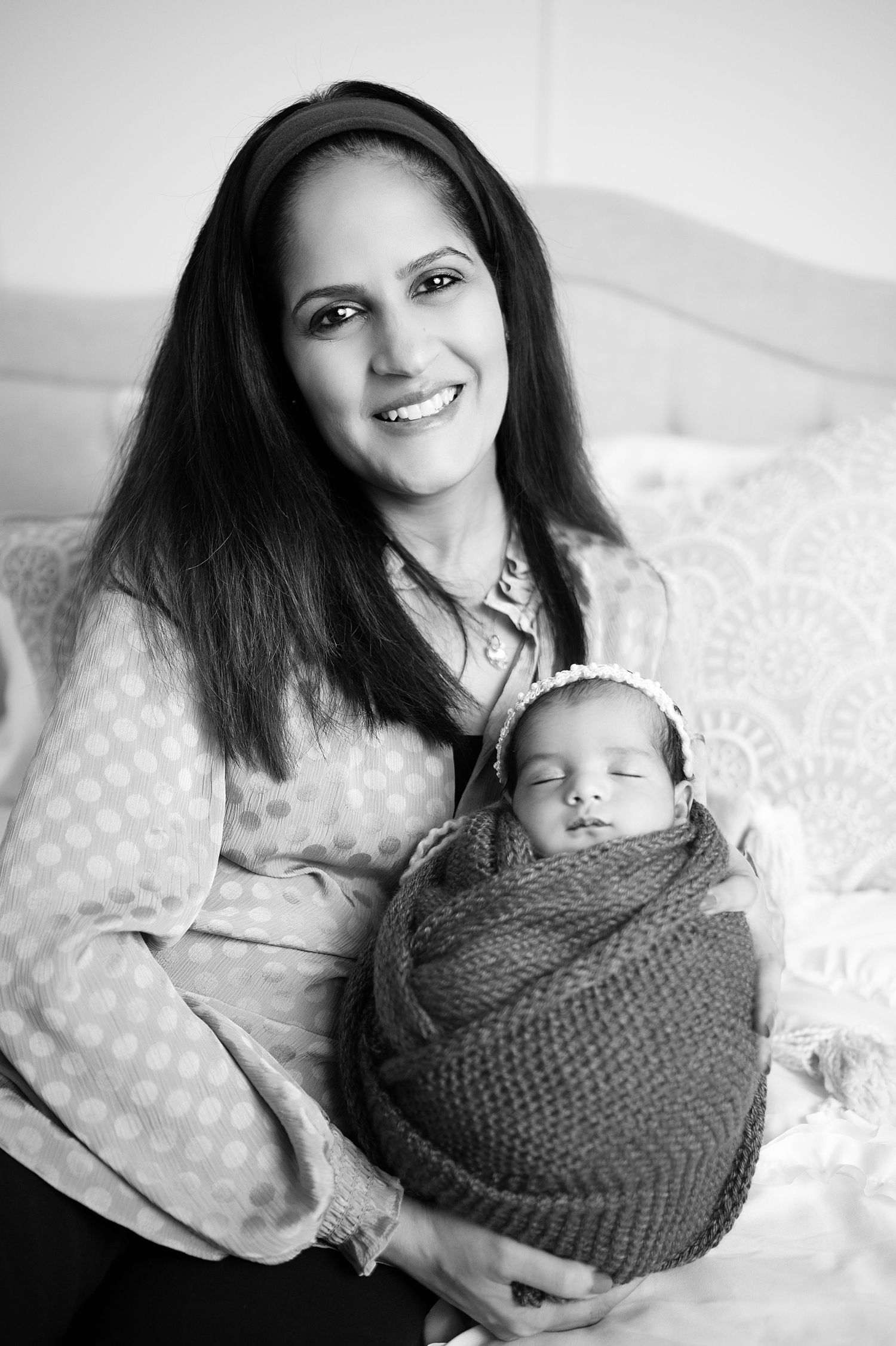 Black and white portraits of tender parent-newborn bonding moments.