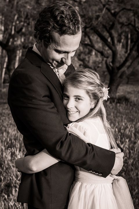 Black and white portrait of couple embracing in romantic outdoor setting.