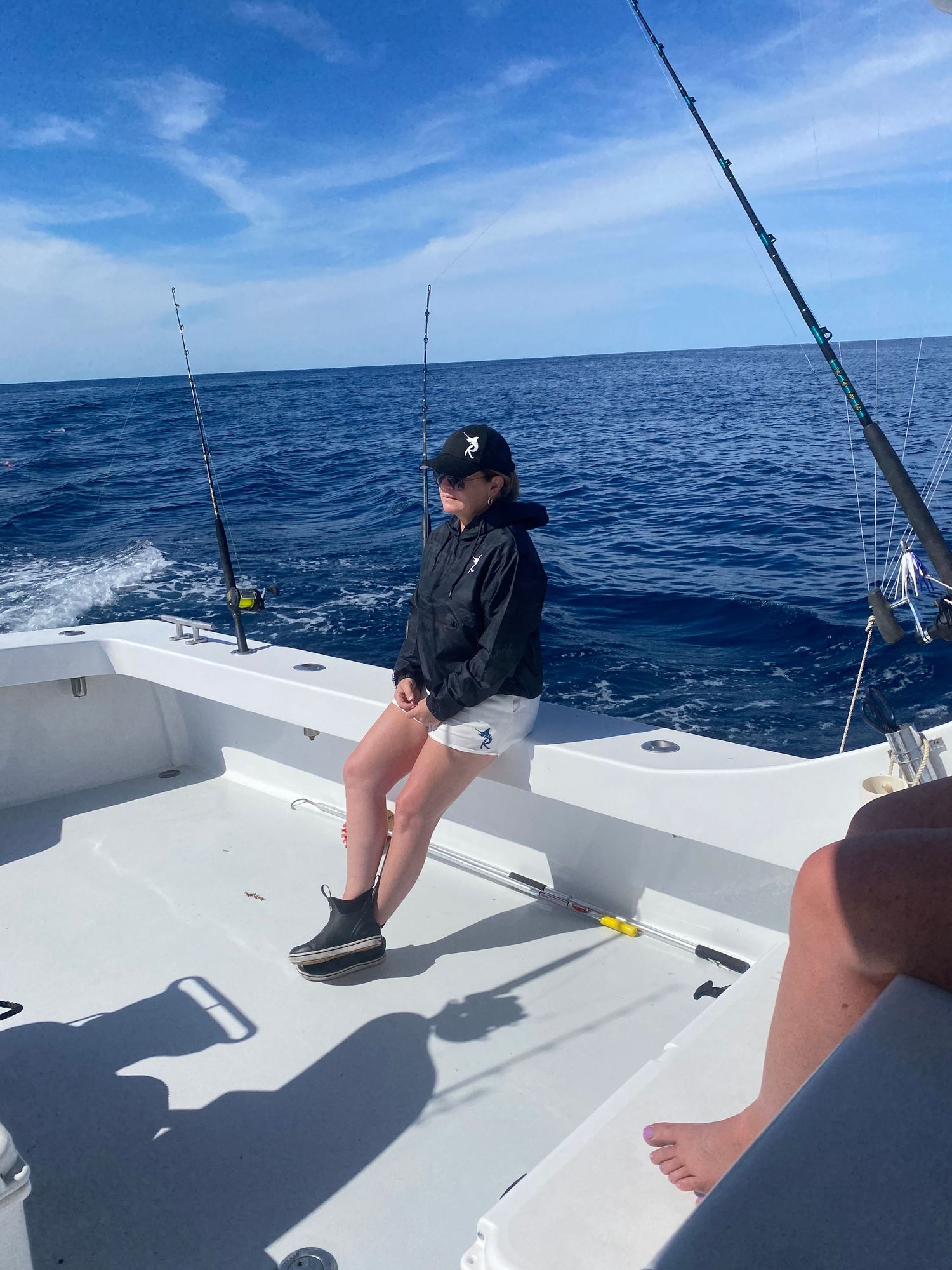 Deep sea fishing setup with multiple rods on white boat deck.