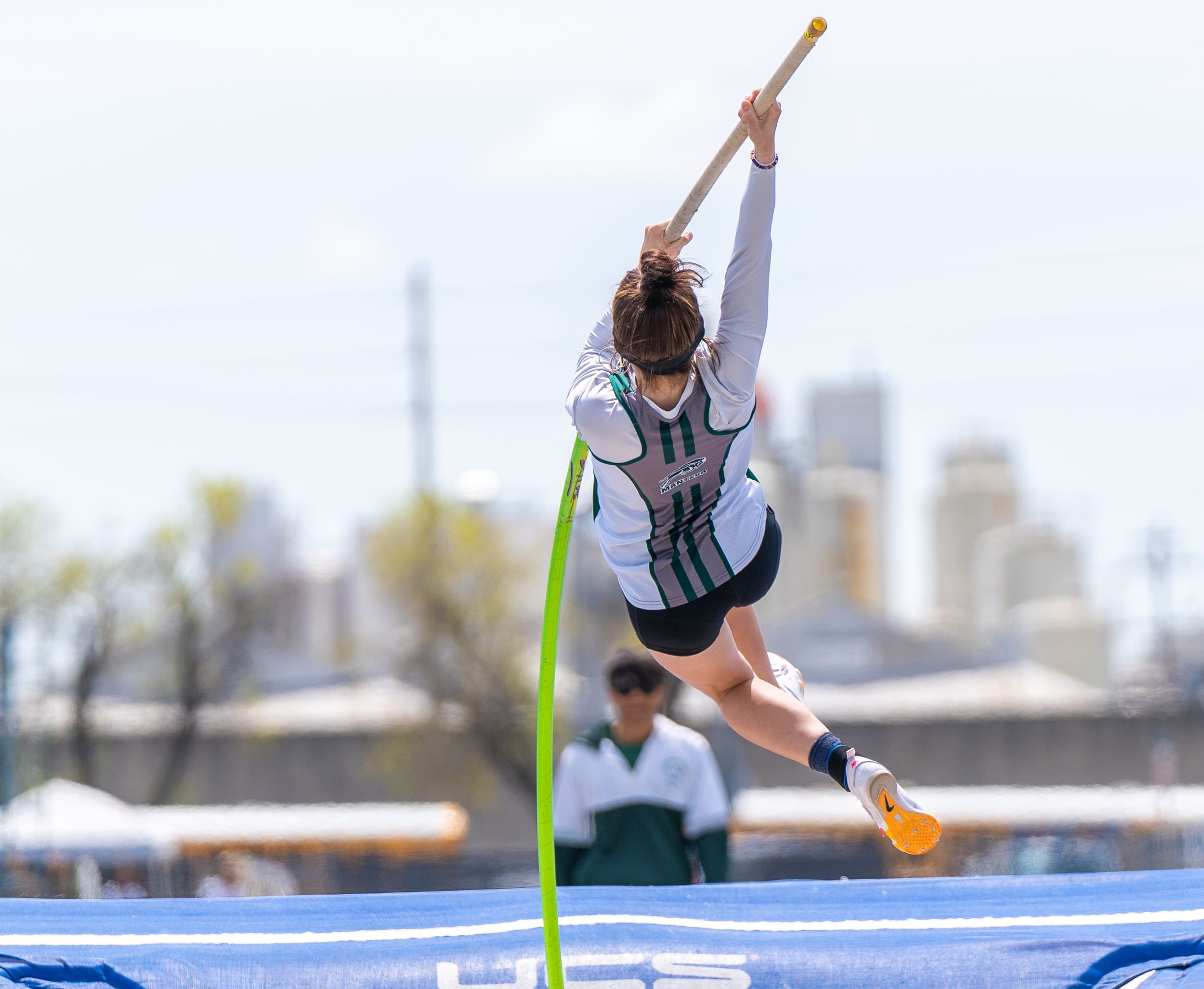 High school pole vaulter soaring through the air with grace and determination