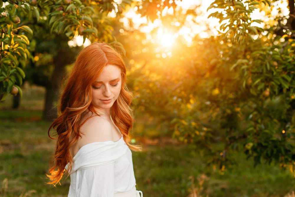 Photo of redhead girl at sunset in a white dress. Professional photographer Sarah Stuckless Photography