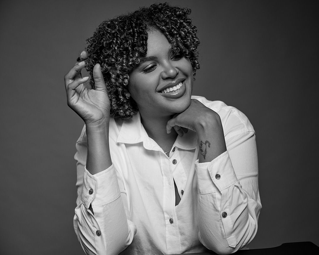 Candid black and white photo capturing natural laughter in casual white shirt.