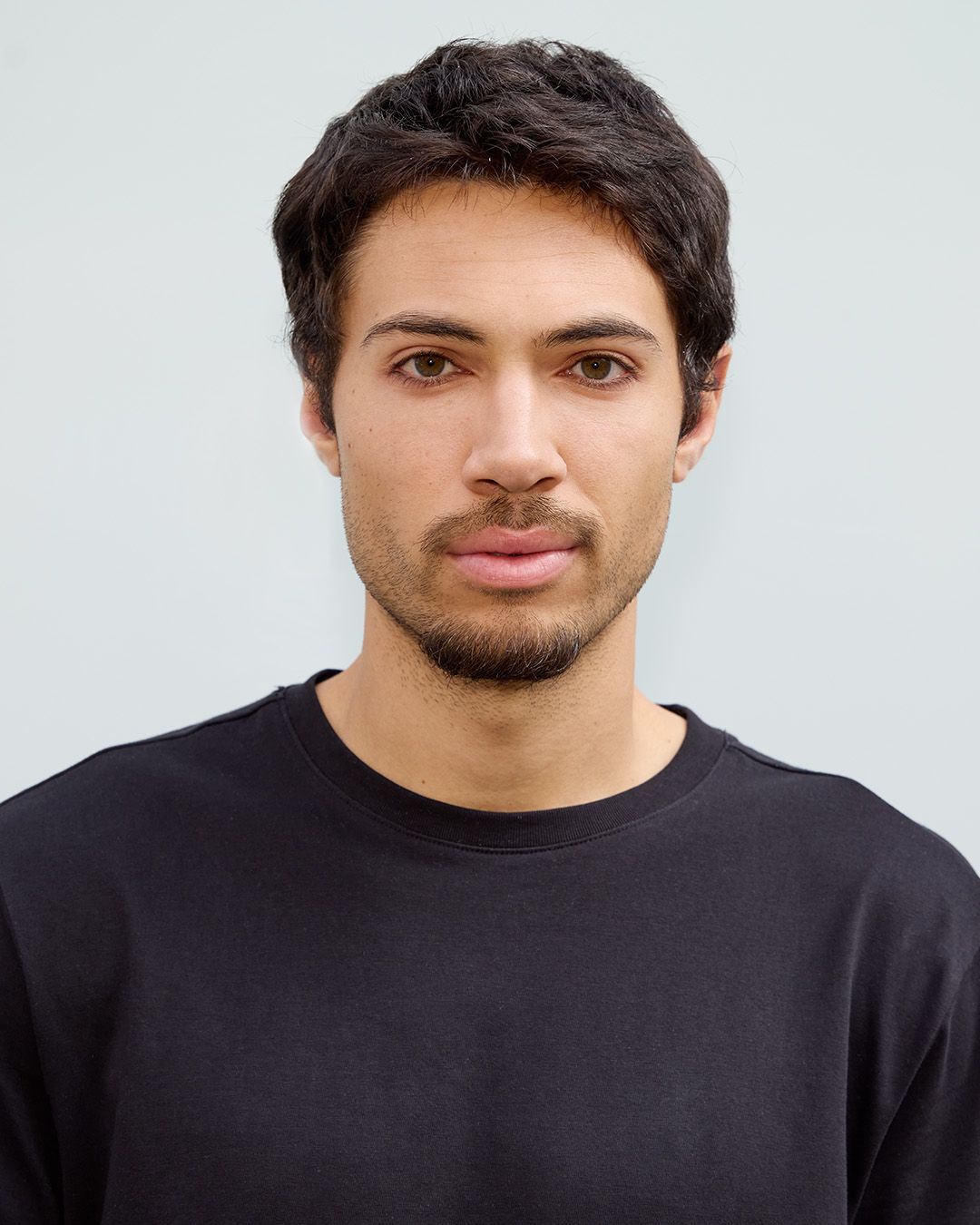 Professional headshot of a person wearing a black sweater against a white background.