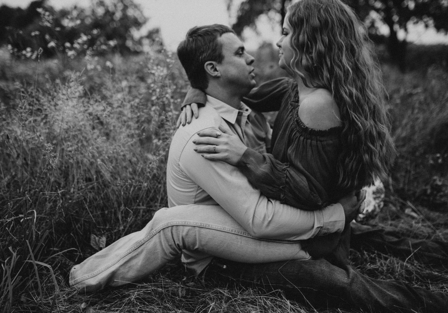 Couple cuddled in tall grass during engagement southwest michigan